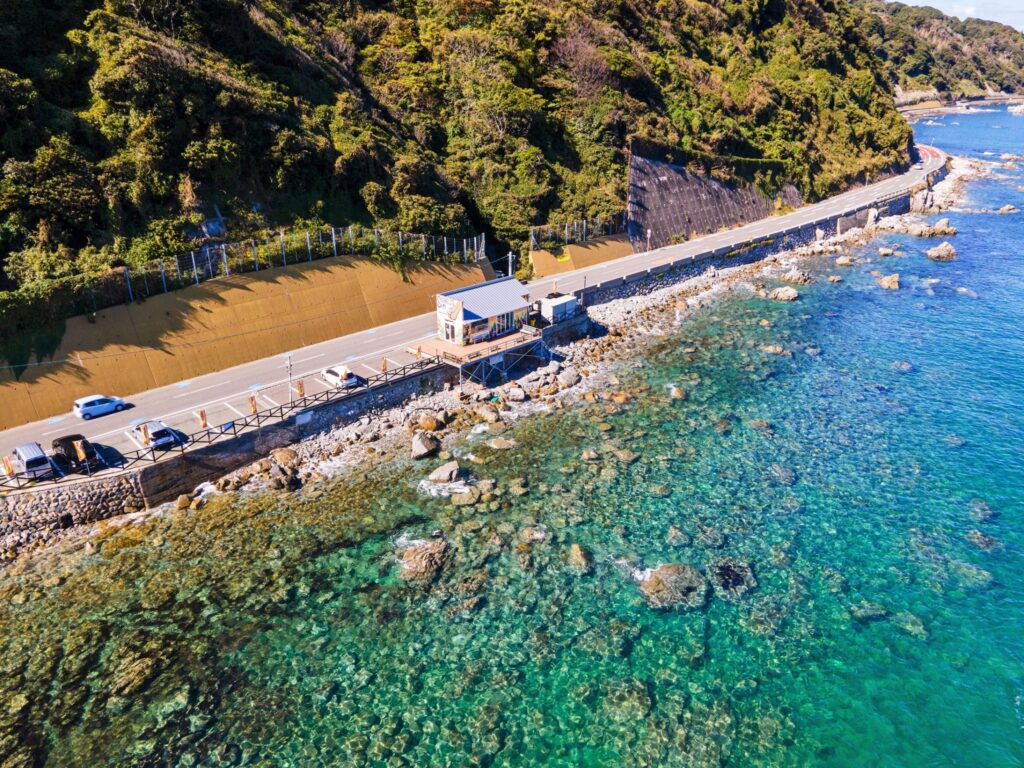 福岡市東区の志賀島の海岸線。透明度の高い海と島沿いの道路が続く志賀島の風景